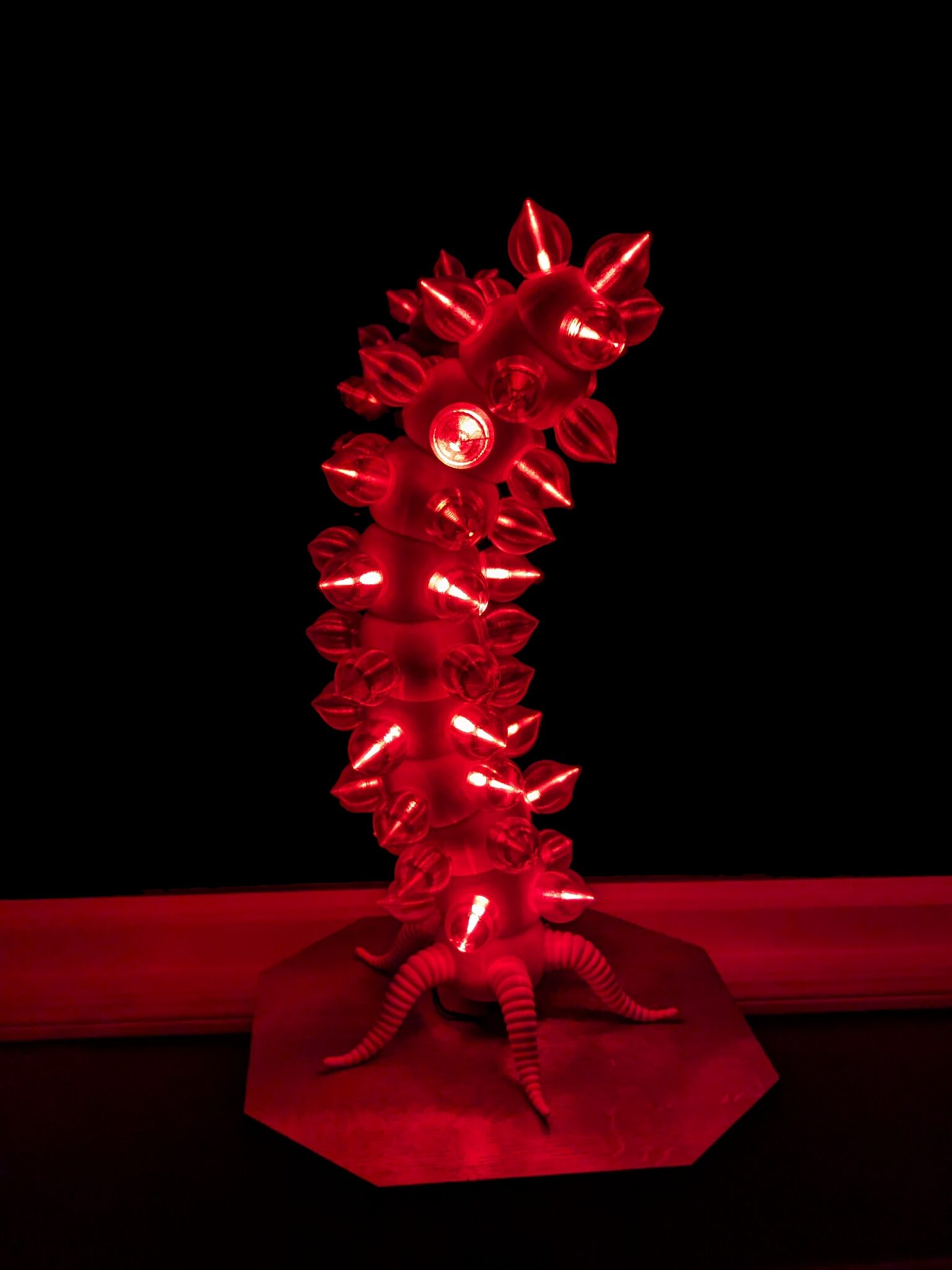 Red colored lights on the biomorphic light sculpture "Electric Fireworm" against a dark background